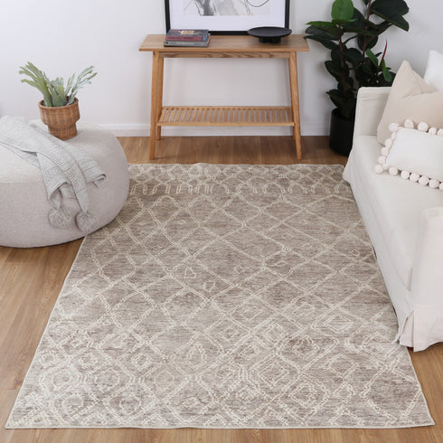 Close-up of a beige rug with gold and taupe accents, featuring NanoWipe technology for easy cleaning and a Fur_riendly™ coating to reduce allergens.